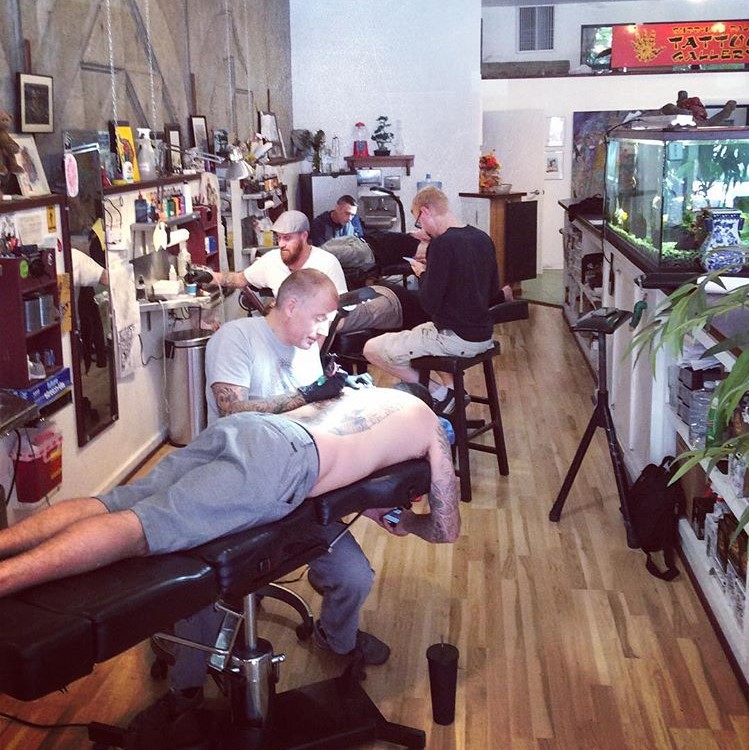 Christian Nolan, Vince Garcia and Clint Hillman all tattooing different people in the shop